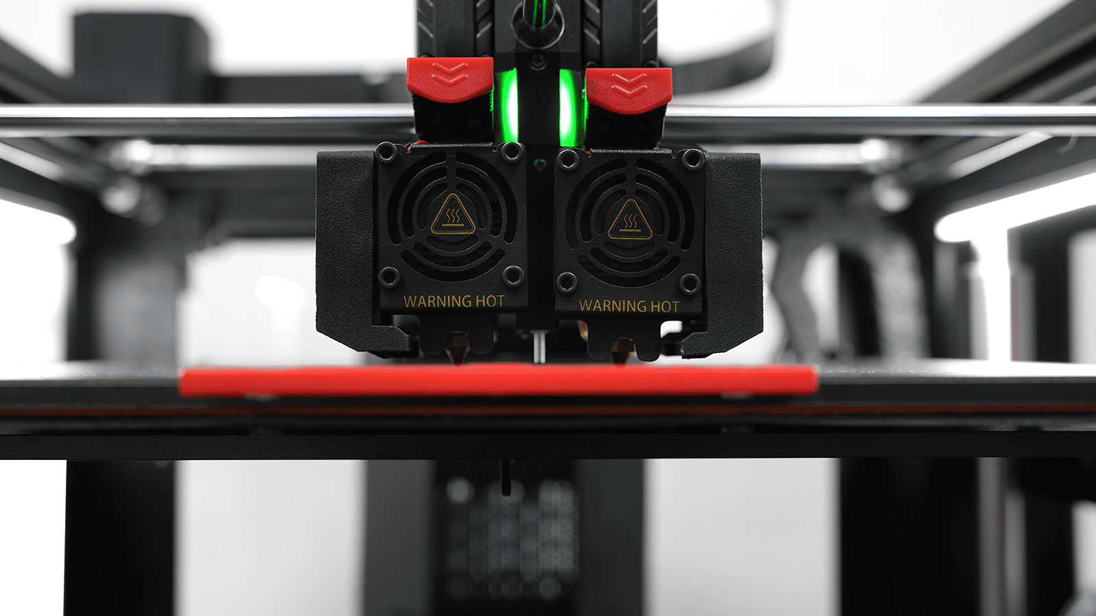 Frontale Nahaufnahme der Dual-Extrudereinheit eines Raise3D Pro3 3D-Druckers mit Warnhinweis "Warning Hot".